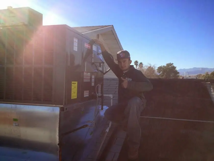 HVAC technician performing Boiler Repair on a rooftop unit in Kodiak
